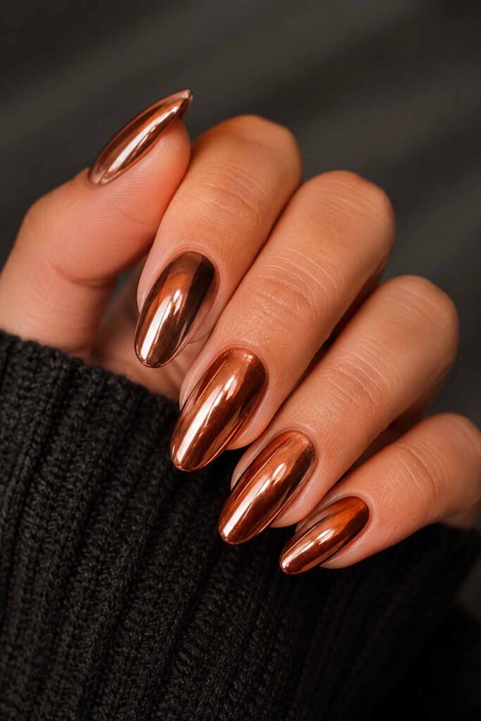 A woman's hand with a metallic copper Halloween manicure