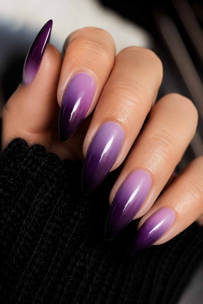 A woman's hand with a purple gradient Halloween manicure