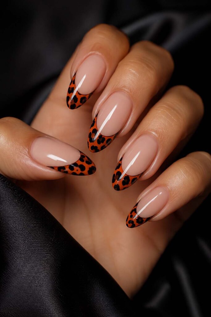 Women's nails with a Halloween French leopard manicure reinterpreted in orange and black