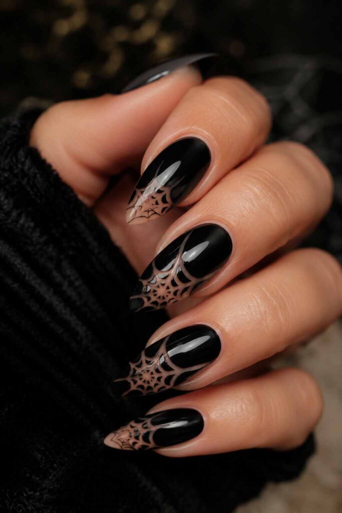 A woman's hand with a Halloween manicure. Spiderweb in negative.